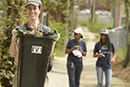 volunteer carrying trash can