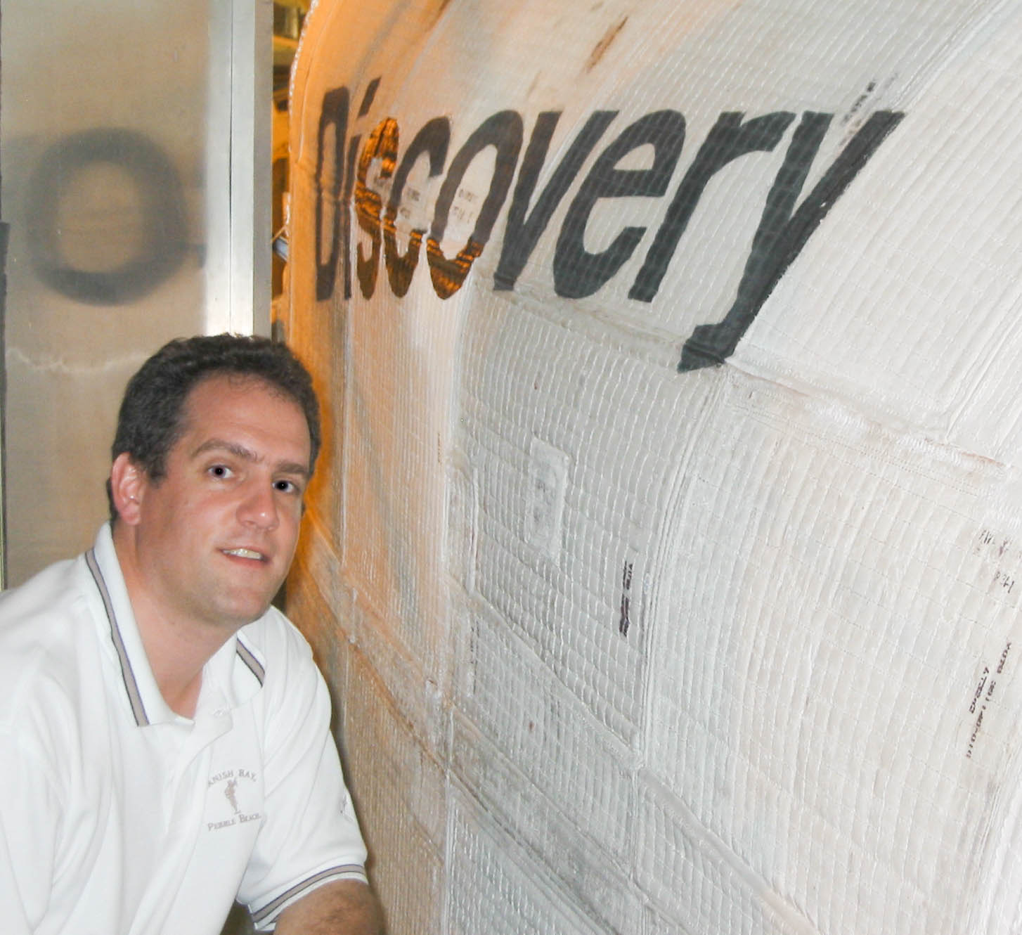 Michael Pryzby poses in front of a rocket, Discovery